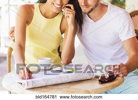 Hispanic couple reading map at cafe View Large Photo Image Stock Image - Hispanic couple reading map at cafe. Fotosearch