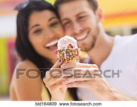 Hispanic couple sharing ice cream cone outdoors View Large Photo Image Stock Photo - Hispanic couple sharing ice cream cone outdoors. Fotosearch