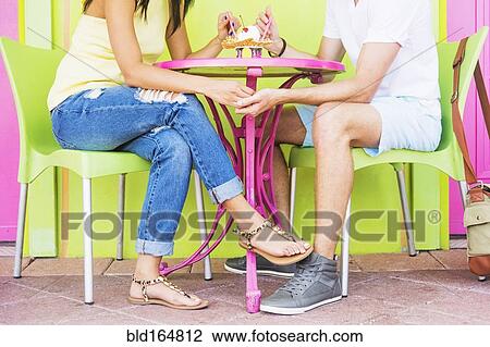 Stock Image - Hispanic couple sharing ice cream sundae. Fotosearch