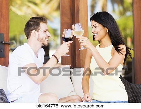 Stock Photography - Hispanic couple toasting with wine. Fotosearch
