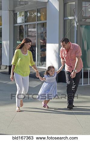 Hispanic family holding hands on sidewalk View Large Photo Image Stock Image - Hispanic family holding hands on sidewalk. Fotosearch