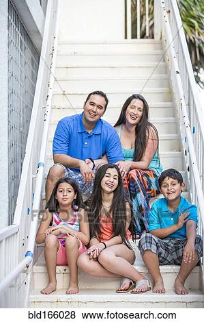 Stock Photo - Hispanic family smiling on staircase. Fotosearch