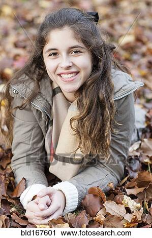 Hispanic girl laying in autumn leaves View Large Photo Image Stock Image - Hispanic girl laying in autumn leaves. Fotosearch