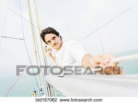 Hispanic man adjusting rigging on sailboat View Large Photo Image Stock Image - Hispanic man adjusting rigging on sailboat. Fotosearch