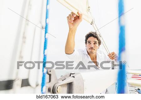 Hispanic man adjusting rigging on sailboat View Large Photo Image Stock Image - Hispanic man adjusting rigging on sailboat. Fotosearch
