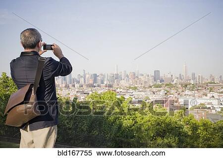 Hispanic man photographing New York cityscape, New York, United States View Large Photo Image Stock Photography - Hispanic man photographing New York cityscape, New York, United States. Fotosearch
