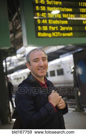 Hispanic man standing on platform in train station View Large Photo Image Stock Photo - Hispanic man standing on platform in train station. Fotosearch