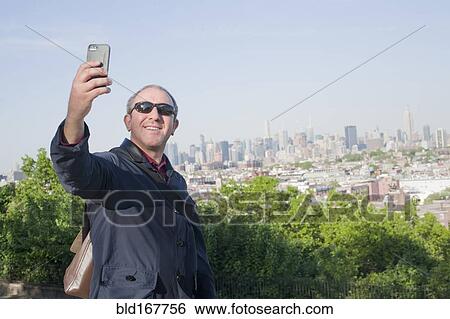 Hispanic man taking selfie with New York cityscape, New York, United States View Large Photo Image Stock Photograph - Hispanic man taking selfie with New York cityscape, New York, United States. Fotosearch