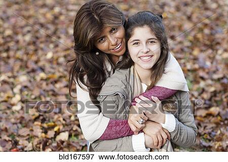 Hispanic mother and daughter hugging in autumn leaves View Large Photo Image Stock Photo - Hispanic mother and daughter hugging in autumn leaves. Fotosearch