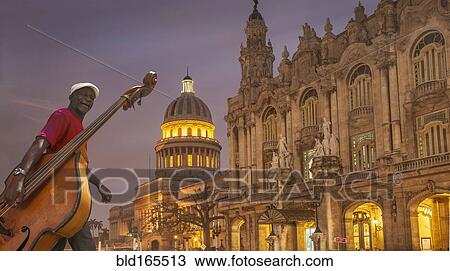 Stock Image - Hispanic musician carrying upright bass in city, Havana, Cuba. Fotosearch