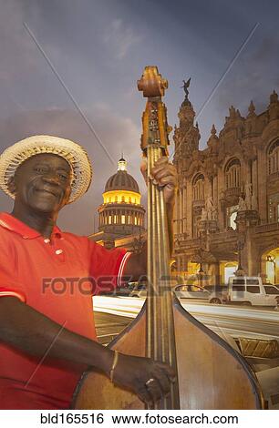 Stock Photograph - Hispanic musician playing upright bass in city, Havana, Cuba. Fotosearch