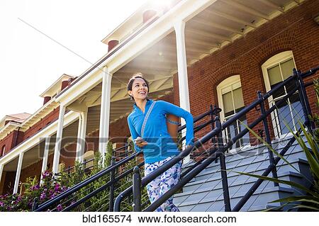 Hispanic woman carrying yoga mat on staircase View Large Photo Image Picture - Hispanic woman carrying yoga mat on staircase. Fotosearch