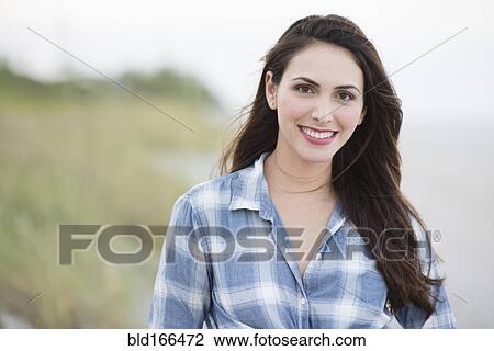 Hispanic woman smiling on beach View Large Photo Image Stock Image - Hispanic woman smiling on beach. Fotosearch