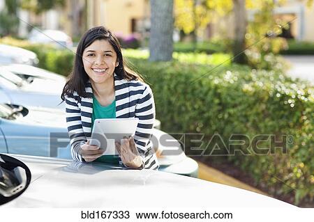 Hispanic woman using digital tablet in parking lot View Large Photo Image Stock Image - Hispanic woman using digital tablet in parking lot. Fotosearch
