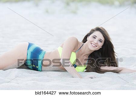 Stock Photo - Hispanic woman wearing bikini on beach. Fotosearch