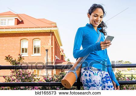 Hispanic woman with yoga mat using cell phone View Large Photo Image Stock Image - Hispanic woman with yoga mat using cell phone. Fotosearch