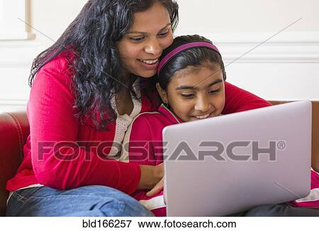 Stock Photo - Indian mother and daughter using laptop. Fotosearch