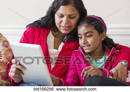 Indian mother and daughter using digital tablet View Large Photo Image Stock Photograph - Indian mother and daughter using digital tablet. Fotosearch