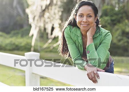 Stock Photography - Indian woman leaning on fence. Fotosearch