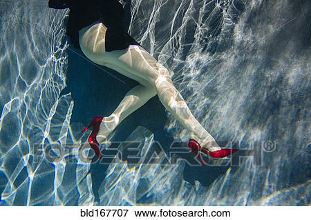 Stock Photo - Legs of woman wearing high heels in swimming pool. Fotosearch