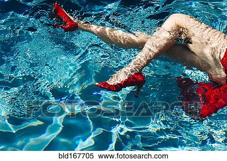 Stock Photography - Legs of woman wearing high heels in swimming pool. Fotosearch