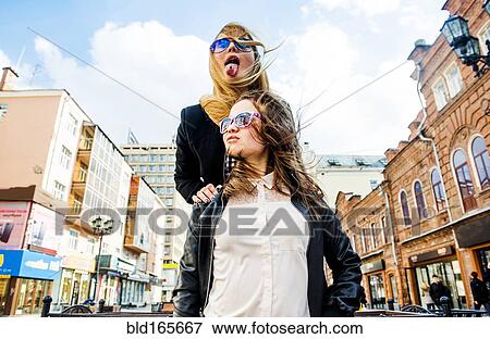 Stock Photo - Low angle view of women playing in city. Fotosearch