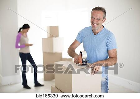 Stock Photo - Man taping cardboard box to move. Fotosearch