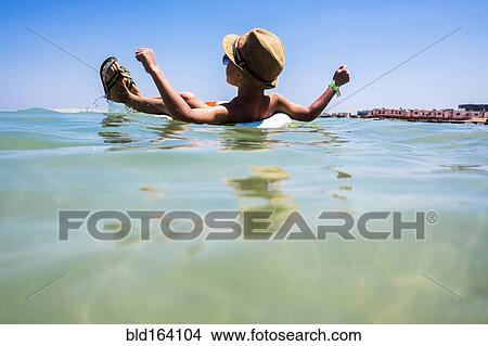 Picture - Mari boy floating in inflatable ring in ocean. Fotosearch