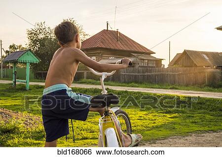 Stock Photograph - Mari boy riding bicycle. Fotosearch
