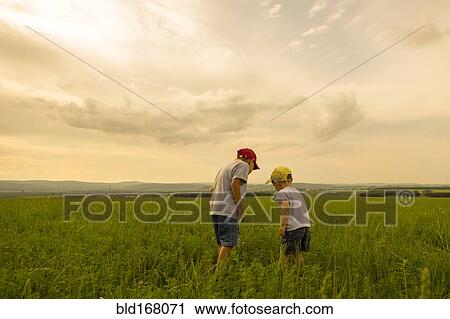 Stock Image - Mari brothers exploring in rural field. Fotosearch