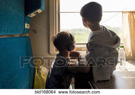 Picture - Mari brothers looking out train window. Fotosearch