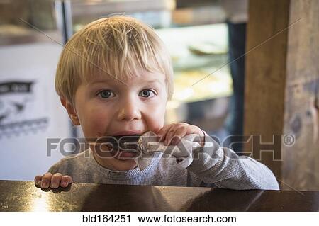 Messy Caucasian boy eating popsicle in kitchen View Large Photo Image Stock Image - Messy Caucasian boy eating popsicle in kitchen. Fotosearch