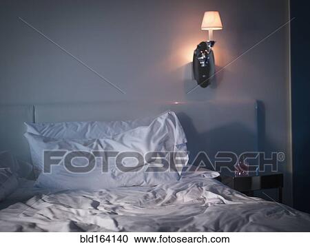 Stock Image - Messy sheets on bed in bedroom. Fotosearch