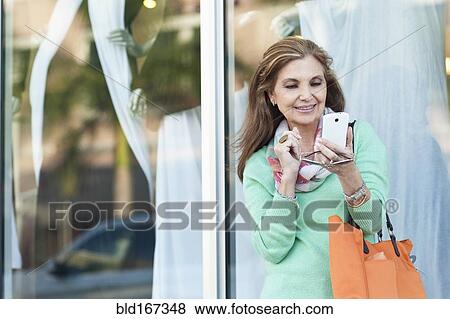 Middle Eastern woman using cell phone outdoors View Large Photo Image Stock Photo - Middle Eastern woman using cell phone outdoors. Fotosearch