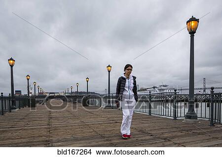 Picture - Middle Eastern woman walking on pier. Fotosearch