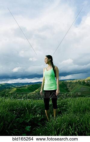 Picture - Mixed race athlete standing in on rural hilltop. Fotosearch