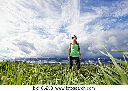 Stock Photo - Mixed race athlete standing in rural field. Fotosearch