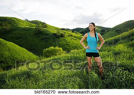 Stock Image - Mixed race athlete standing on rural hillside. Fotosearch