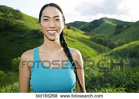 Stock Photo - Mixed race athlete standing on rural hillside. Fotosearch
