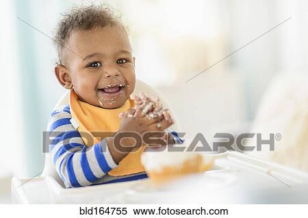 Mixed race baby boy eating in high chair View Large Photo Image Stock Photography - Mixed race baby boy eating in high chair. Fotosearch