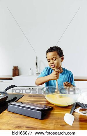 Mixed race boy cooking breakfast with digital tablet in kitchen View Large Photo Image Stock Photo - Mixed race boy cooking breakfast with digital tablet in kitchen. Fotosearch