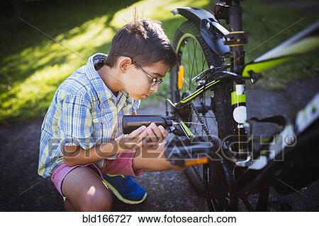 Mixed race boy oiling bicycle chain in backyard View Large Photo Image Stock Photo - Mixed race boy oiling bicycle chain in backyard. Fotosearch