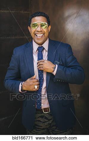 Mixed race businessman adjusting his tie View Large Photo Image Stock Image - Mixed race businessman adjusting his tie. Fotosearch