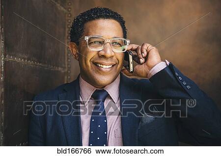 Stock Photograph - Mixed race businessman talking on cell phone. Fotosearch