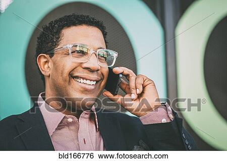 Stock Photograph - Mixed race businessman talking on cell phone. Fotosearch