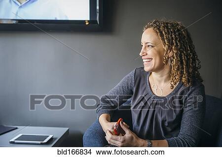 Picture - Mixed race businesswoman laughing in office lobby. Fotosearch