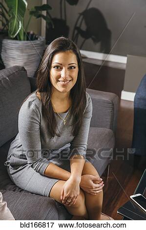 Stock Photo - Mixed race businesswoman sitting in office lobby. Fotosearch