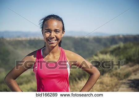 Stock Photo - Mixed race girl smiling on hillside path. Fotosearch