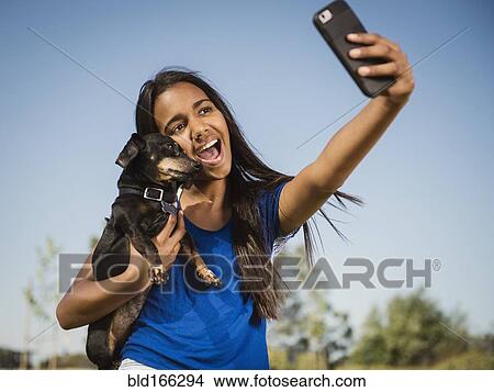 Mixed race girl taking selfie with dog View Large Photo Image Picture - Mixed race girl taking selfie with dog. Fotosearch