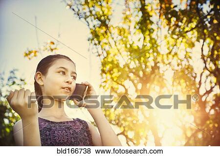 Stock Photo - Mixed race girl talking on cell phone outdoors. Fotosearch